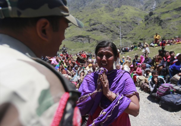 A survivor pleads with a soldier to allow her mother to board an army helicopter during rescue operations at Badrinath in the Himalayan state of Uttarakhand