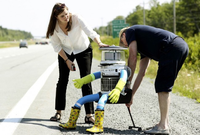 Dr. Frauke Zeller and Dr. David Smith place their anthropomorphic robot named hitchBOT onto the shoulder of Highway 102 outside of Halifax, Nova Scotia
