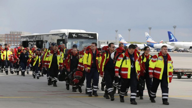 Members of Germany's NGO organistation International Search and Rescue (ISAR- Germany) arrive to board their flight to Nepal via Delhi, at Frankfurt airport April 26, 2015. Some seven rescue dogs, 51 doctors, medics and logistical experts are flying to Nepal on Sunday, a day after a 7.9 magnitude earthquake devastated the heavily crowded Kathmandu Valley, killing more than 2,200 people, and triggered a deadly avalanche on Mount Everest.  REUTERS/Wolfgang Rattay