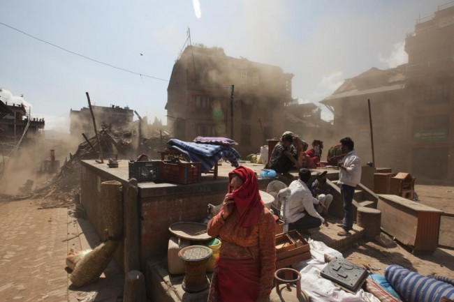 Nepalese residents gather in an open space at the site of destruction caused after Saturday's earthquake in Bhaktapur, on the outskirts of Kathmandu, Nepal, Monday, April 27, 2015. A strong magnitude earthquake shook Nepals capital and the densely populated Kathmandu valley on Saturday devastating the region and leaving tens of thousands shell-shocked and sleeping in streets. (AP Photo/Niranjan Shrestha)