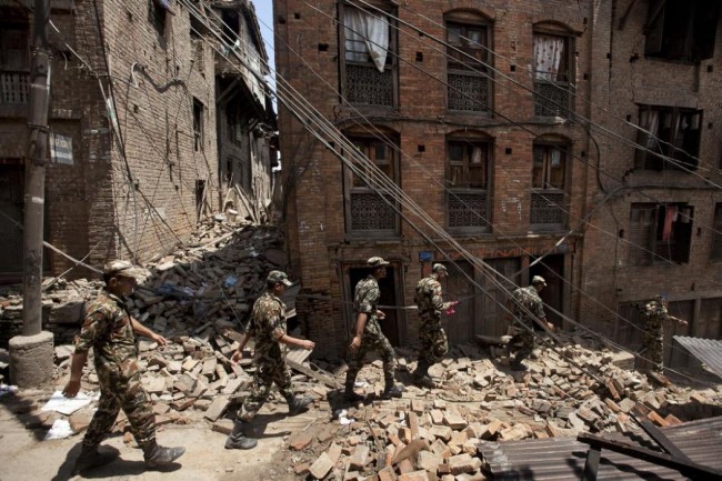 Members of the Nepalese army walk through a damaged area caused by Saturday's earthquake, in Bhaktapur, on the outskirts of Kathmandu, Nepal, Monday, April 27, 2015. A strong magnitude earthquake shook Nepals capital and the densely populated Kathmandu valley on Saturday devastating the region and leaving tens of thousands shell-shocked and sleeping in streets. (AP Photo/Niranjan Shrestha)