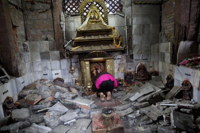 A Hindu Nepalese woman offers prayers at Indrayani temple, that was damaged in Saturdays earthquake, in Kathmandu, Nepal, Monday, April 27, 2015. A strong magnitude earthquake shook Nepals capital and the densely populated Kathmandu valley on Saturday devastating the region and leaving tens of thousands shell-shocked and sleeping in streets. (AP Photo/Bernat Armangue)