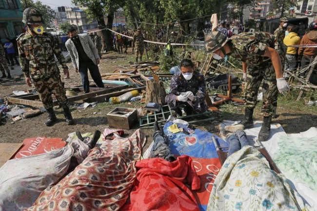Rescue teams' members identify bodies dug out of the collapsed Sitapyla church in Kathmandu, Nepal, Monday, April 27, 2015. A strong magnitude 7.8 earthquake shook Nepal's capital and the densely populated Kathmandu Valley on Saturday, causing extensive damage with toppled walls and collapsed buildings. (AP Photo/Wally Santana)