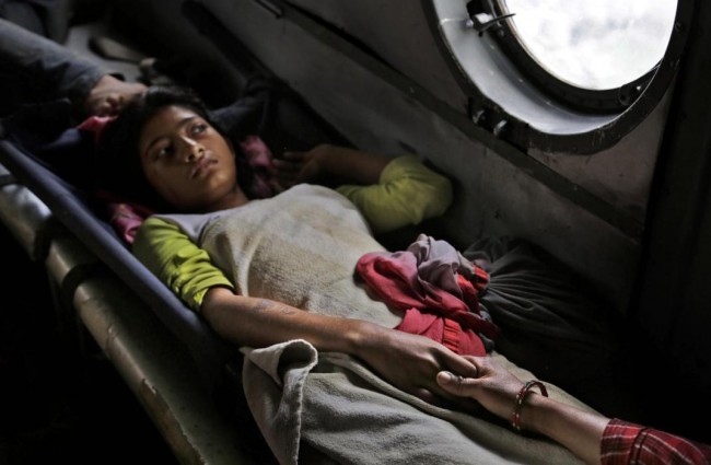 A Nepalese girl injured in Saturdays earthquake holds the hand of her mother inside an Indian air force helicopter as they are evacuated from Trishuli Bazar to Kathmandu airport in Nepal, Monday, April 27, 2015. The death toll from Nepal's earthquake is expected to rise depended largely on the condition of vulnerable mountain villages that rescue workers were still struggling to reach two days after the disaster.  (AP Photo/Altaf Qadri)