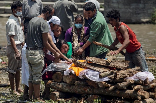 A woman cries as her father's body is prepared for cremation along a river, following Saturday's earthquake, in Kathmandu, Nepal, April 27, 2015. The man died during the 7.9 magnitude earthquake that hit the country on Saturday.    REUTERS/Danish Siddiqui      TPX IMAGES OF THE DAY