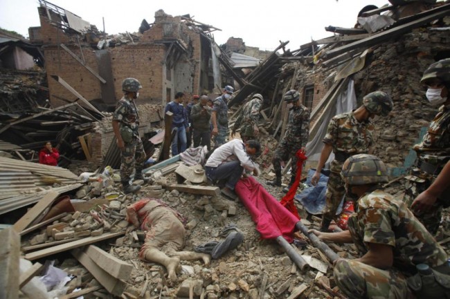 A dead body of a woman is seen after rescue workers recovered it from debris following Saturday's earthquake in Bhaktapur near Kathmandu, Nepal, Sunday, April 26, 2015. A strong earthquake shook Nepal's capital and the densely populated Kathmandu Valley before noon Saturday, causing extensive damage with toppled walls and collapsed buildings, officials said. (AP Photo/Niranjan Shrestha)