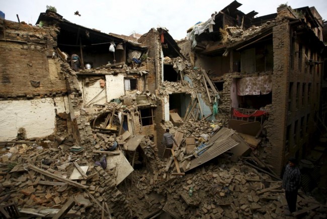 People search for family members trapped inside collapsed houses a day after an earthquake in Bhaktapur, Nepal April 26, 2015. A shallow earthquake measuring 7.9 magnitude struck west of the ancient Nepali capital of Kathmandu on Saturday, killing more than 100 people, injuring hundreds and leaving a pall over the valley, doctors and witnesses said. (REUTERS/Navesh Chitrakar)