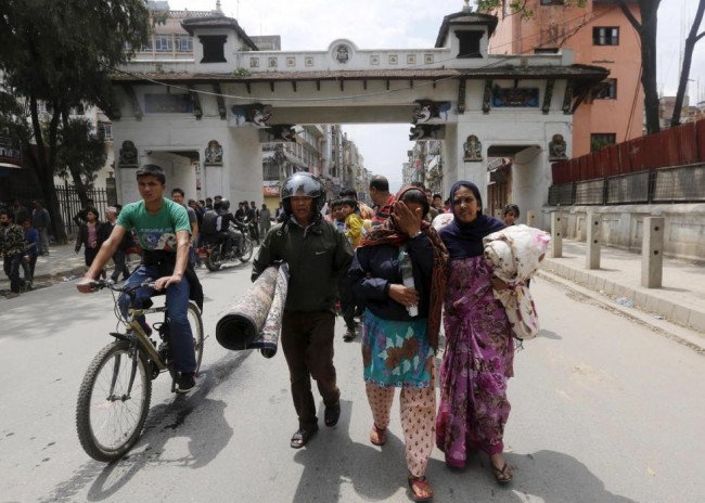 A family carry their belongings as they rush for safety during a strong aftershock after an earthquake, in Kathmandu, Nepal April 26, 2015. Rescuers dug with their bare hands and bodies piled up in Nepal on Sunday after the earthquake devastated the heavily crowded Kathmandu Valley, killing more than 2,200 people, and triggered a deadly avalanche on Mount Everest. (REUTERS/Adnan Abidi)