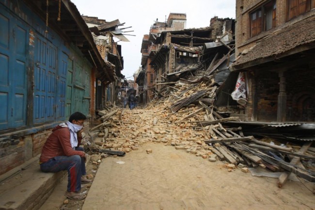 A Nepalese man mourns as he sits near the debris after an earthquake in Bhaktapur near Kathmandu, Nepal, Sunday, April 26, 2015. A strong magnitude 7.8 earthquake shook Nepal's capital and the densely populated Kathmandu Valley before noon Saturday, causing extensive damage with toppled walls and collapsed buildings, officials said. (AP Photo/Niranjan Shrestha)