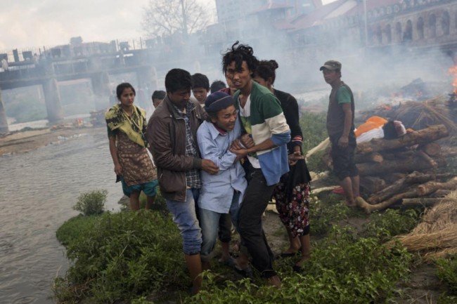 A Hindu man breaks down during a funeral of Saturday’s earthquake victims on the Pashupatinath bank of Bagmati river, in Kathmandu, Nepal, Sunday, April 26, 2015.  The earthquake centered outside Kathmandu, the capital, was the worst to hit the South Asian nation in over 80 years. It destroyed swaths of the oldest neighborhoods of Kathmandu, and was strong enough to be felt all across parts of India, Bangladesh, China's region of Tibet and Pakistan.(AP Photo/Bernat Armangue)