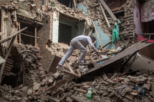 A man climbs on top of debris after buildings collapsed on April 26, 2015 in Bhaktapur, Nepal. (Omar Havana/Getty Images)