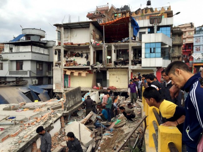 People survey a site damaged by an earthquake, in Kathmandu, Nepal, April 25, 2015. The shallow earthquake measuring 7.9 magnitude struck west of the ancient Nepali capital of Kathmandu on Saturday, killing more than 100 people, injuring hundreds and leaving a pall over the valley, doctors and witnesses said.  (REUTERS/Navesh Chitrakar)