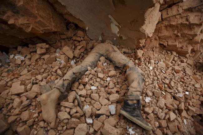 A body of a victim lies trapped in the debris after an earthquake hit, in Kathmandu, Nepal April 25, 2015. The shallow earthquake measuring 7.9 magnitude struck west of the ancient Nepali capital of Kathmandu on Saturday, killing more than 100 people, injuring hundreds and leaving a pall over the valley, doctors and witnesses said. (REUTERS/Navesh Chitrakar)