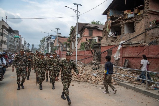 An army patrol walks in the city center looking at the damage following an earthquake on April 25, 2015 in Kathmandu, Nepal. (Photo by Omar Havana/Getty Images)