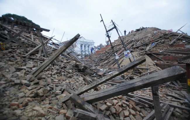 Debris lie at Durbar Square after an earthquake in Kathmandu, Nepal, Saturday, April 25, 2015. A strong magnitude-7.9 earthquake shook Nepal's capital and the densely populated Kathmandu Valley before noon Saturday, causing extensive damage with toppled walls and collapsed buildings, officials said. (AP Photo/ Niranjan Shrestha)