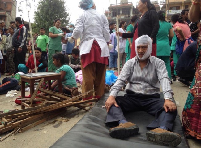 Injured people receive treatment outside the Medicare Hospital in Kathmandu, Nepal, Saturday, April 25, 2015. A strong magnitude-7.9 earthquake shook Nepal's capital and the densely populated Kathmandu Valley before noon Saturday, causing extensive damage with toppled walls and collapsed buildings, officials said. (AP Photo/ Niranjan Shrestha)