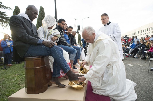In this handout picture released by the Vatican Press Office, Pope Francis performs the foot-washing ritual at the Castelnuovo di Porto refugees center near Rome on March 24, 2016. Pope Francis washed the feet of 11 young asylum seekers and a worker at their reception centre to highlight the need for the international community to provide shelter to refugees. Several of the asylum seekers, one holding a baby in her arms, were reduced to tears as the 79-year-old pontiff kneeled before them, pouring water over their feet, drying them with a towel and bending to kiss them. / AFP / STR / RESTRICTED TO EDITORIAL USE - MANDATORY CREDIT "AFP PHOTO / OSSERVATORE ROMANO" - NO MARKETING NO ADVERTISING CAMPAIGNS - DISTRIBUTED AS A SERVICE TO CLIENTS