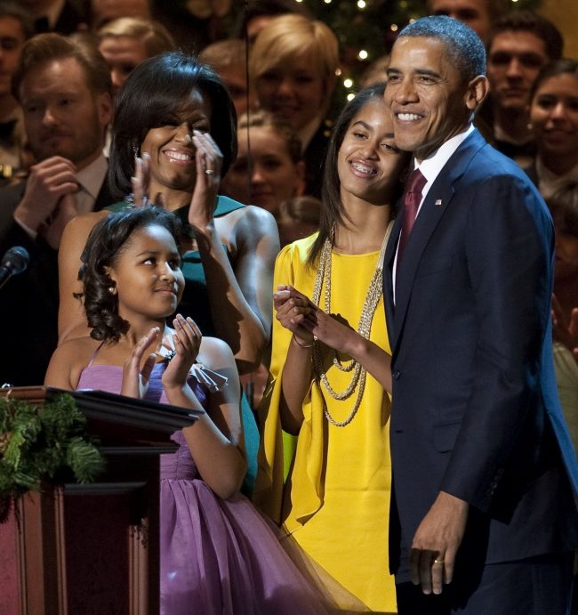 US President Barack Obama, First Lady Michelle Obama (L) and their daughters, Sasha (2nd L) and Malia (2nd R), after Obama spoke during the taping of "Christmas in Washington," at the National Building Museum in Washington, DC, December 11, 2011. The show, hosted by Conan O'Brien, features performances and appearances by Justin Bieber, Cee Lo Green, Jennifer Hudson, Victoria Justice and The Band Perry and airs on television December 16. AFP PHOTO / Saul LOEB (Photo credit should read SAUL LOEB/AFP/Getty Images)