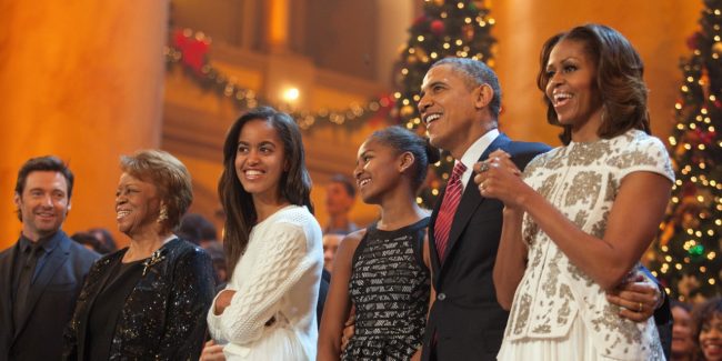 WASHINGTON, DC - DECEMBER 15:  U.S. President Barack Obama and first lady Michelle Obama, along with daughters Malia (left) and Sasha, sing during the finale of TNT's "Christmas in Washington" on December 15, 2013 in Washington, DC.  The program benefits the Children's National Health System. Also shown are the president's mother-in-law, Marian Robinson, and the program's host, actor Hugh Jackman. (Photo by Martin H. Simon-Pool/Getty Images)