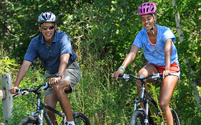 WEST TISBURY , MA - AUGUST 16: U.S. President Barack Obama (L) his daughter Malia Obama ride a bike during a vacation on Martha's Vineyard August 16, 2013in West Tisbury, Massachusetts. Obama and his family are on a weeklong vacation.  (Photo by Rick Friedman-Pool/Getty Images)