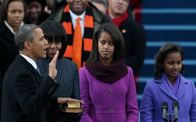 WASHINGTON, DC - JANUARY 21:  U.S. President Barack Obama (L) is sworn inas First lady Michelle Obama and daughters, Sasha Obama (R) and Malia Obama look on during the public ceremonial inauguration on the West Front of the U.S. Capitol January 21, 2013 in Washington, DC.   Barack Obama was re-elected for a second term as President of the United States.  (Photo by Justin Sullivan/Getty Images)